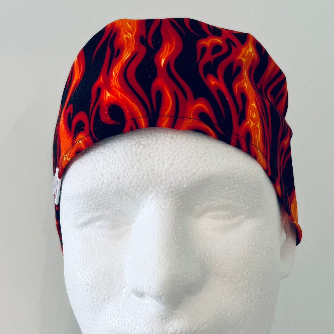 Flame print scrub cap in orange & black fire on a model — handmade-in-USA men's tie-back surgical cap from OR World.
