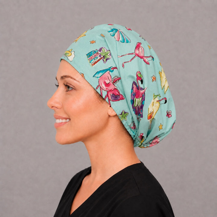 Woman wearing a flamingo beach Euro scrub cap, front view — pink flamingos and palm trees on aqua, adjustable tropical surgical hat for nurses