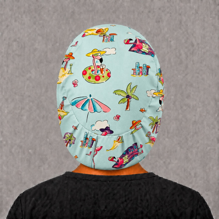 Back view of the flamingo beach Euro scrub cap — full coverage showing flamingos, palms and beach umbrellas across the aqua crown