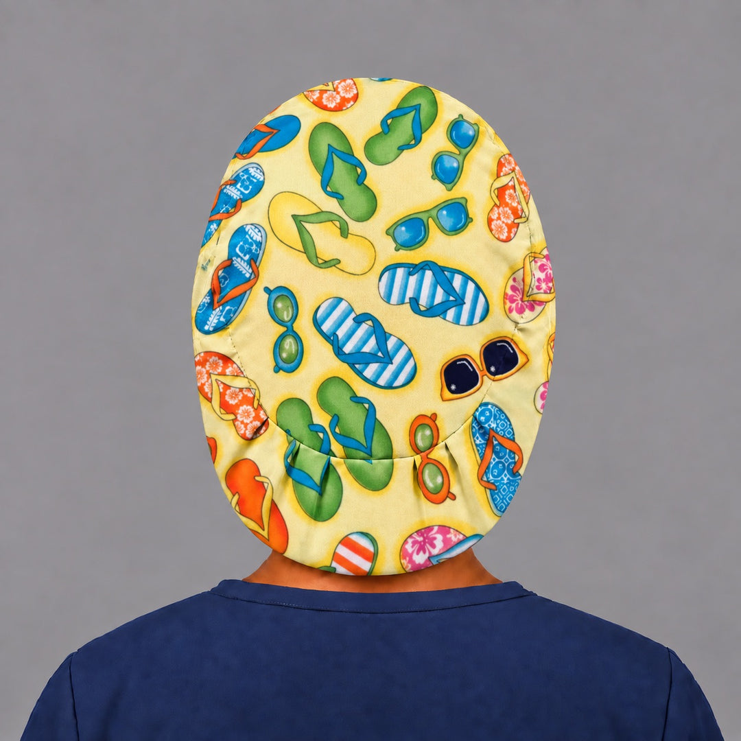 Woman wearing a Flip Flops &amp; Sunglasses Euro scrub cap, front view — colorful flip flops on sunny yellow, adjustable beach theme surgical hat