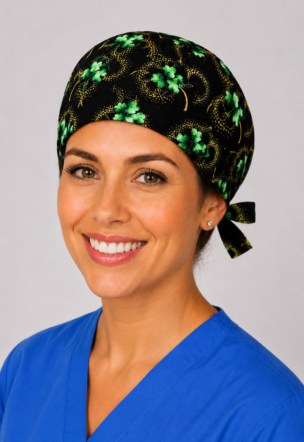 Three-quarter view of four-leaf clover black scrub cap with gold swirls, unisex adjustable surgical hat for nurses and techs