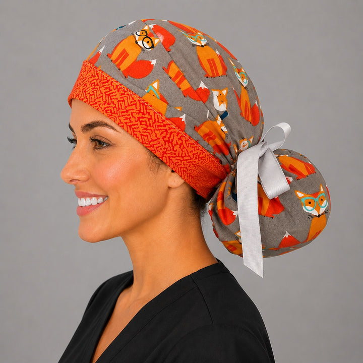 Fox print ponytail scrub cap angled view on model, gray surgical hat with orange foxes, ponytail style for long hair, handmade USA, OR World