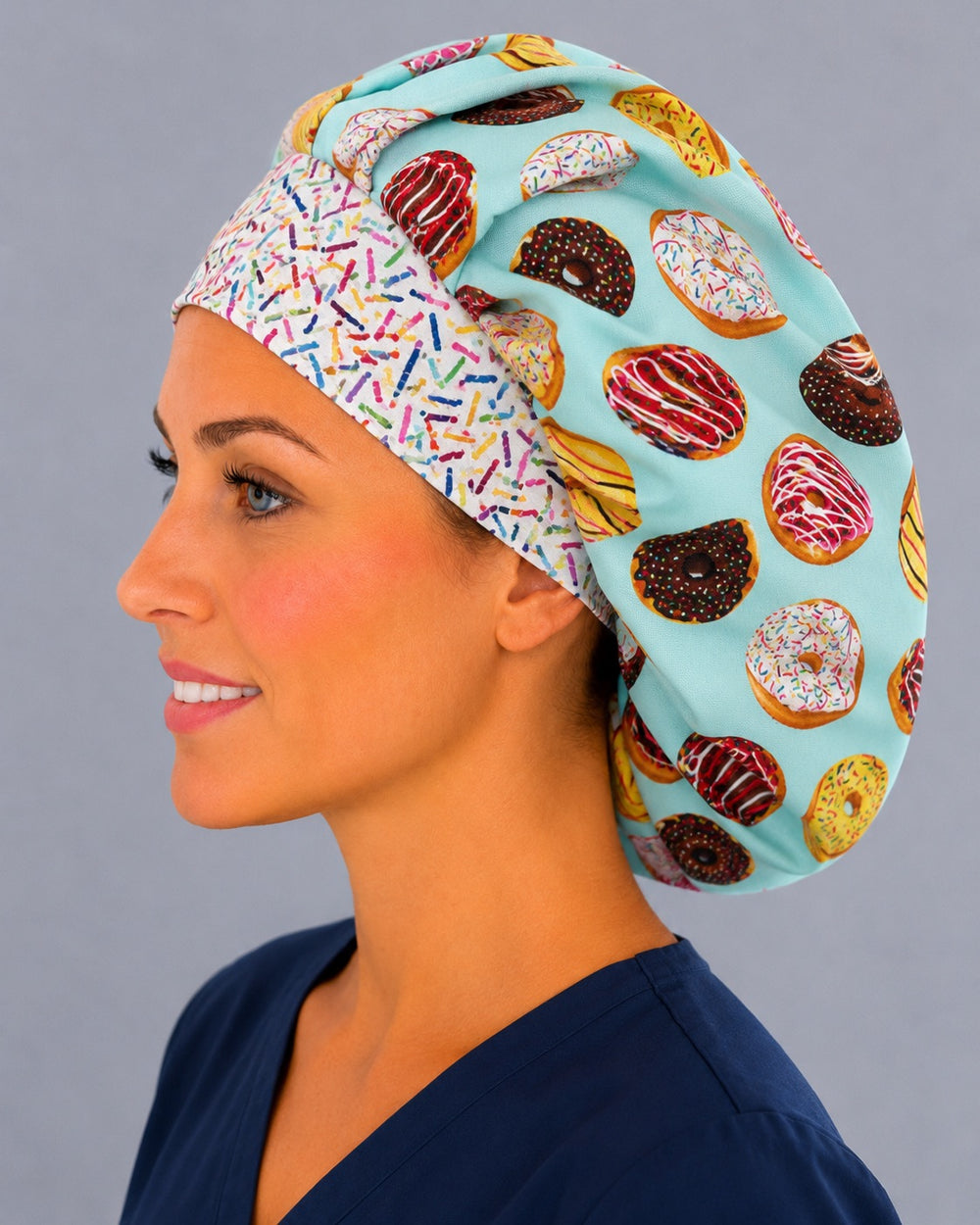 Side view of the frosted donut bouffant surgical cap — chocolate and sprinkle doughnuts on aqua with confetti sprinkle band, roomy cotton cap for nurses