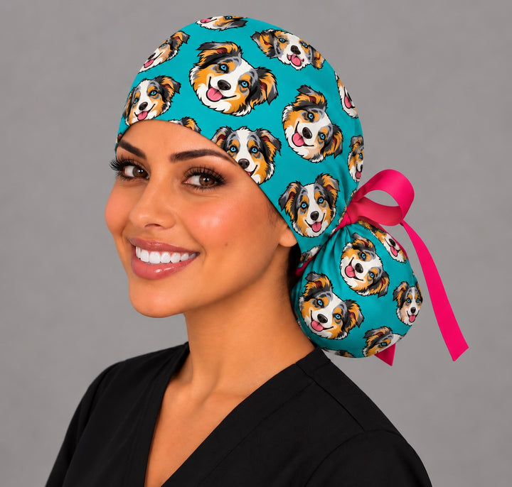 Surgical nurse wearing a funny custom cartoon pet ponytail scrub cap in teal with a personalized Australian shepherd print and pink ribbon, handmade USA by OR World