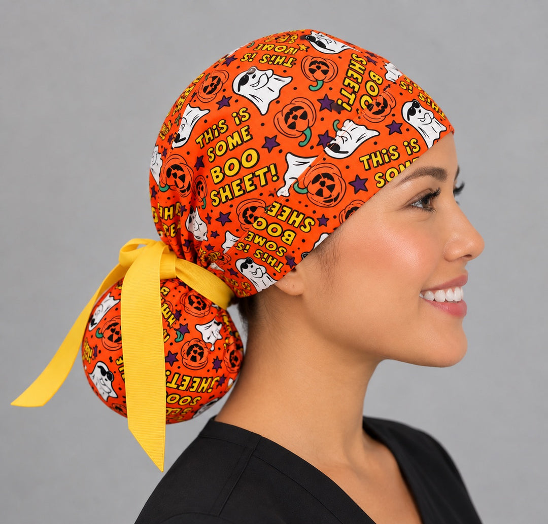 Right side profile of the funny ghost ponytail surgical hat — golden yellow bow over the deep ponytail pouch, breathable cotton cap