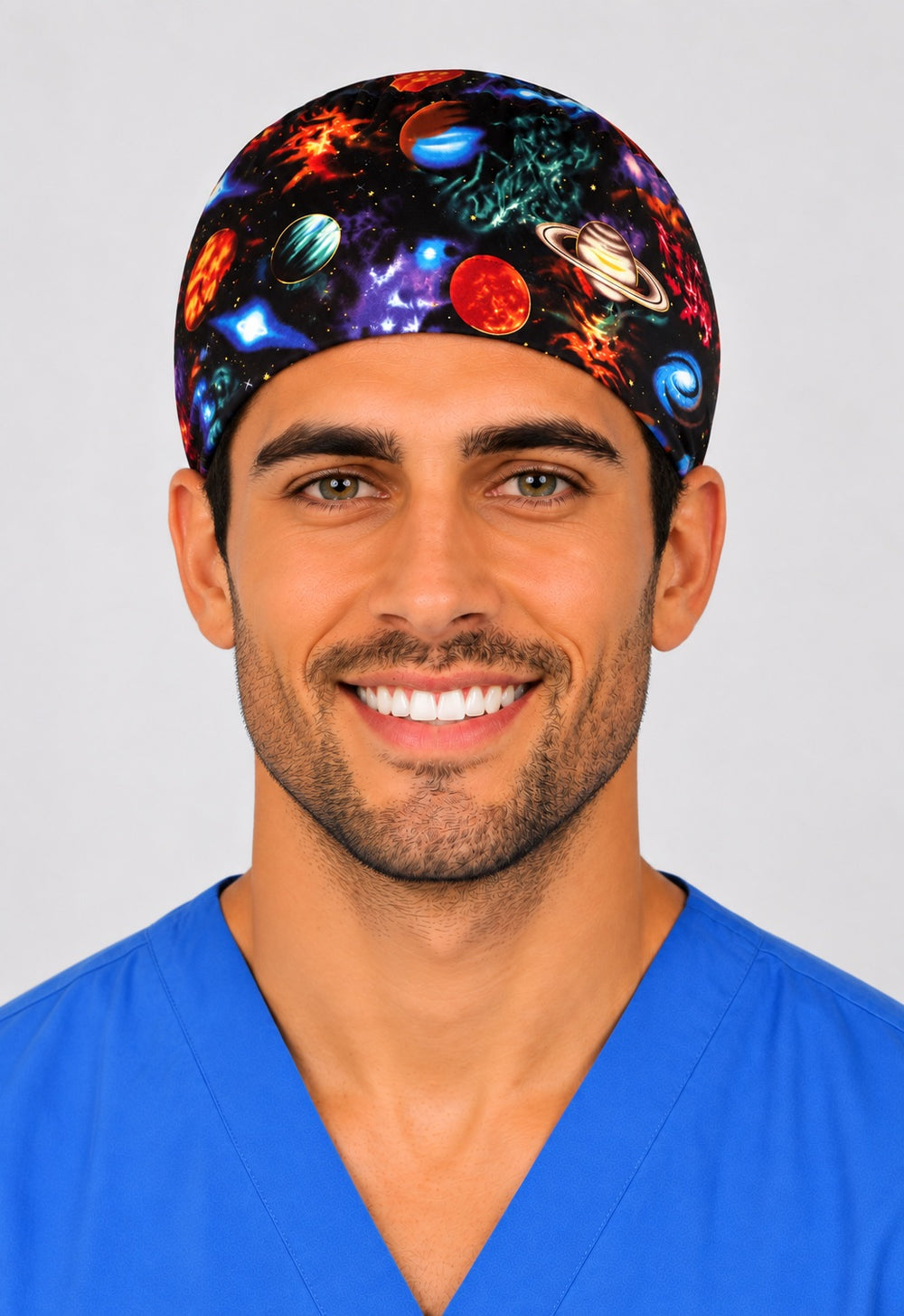 Front-facing view of male surgical tech in galaxy planets scrub cap with Saturn and nebula print — adjustable tie-back OR cap