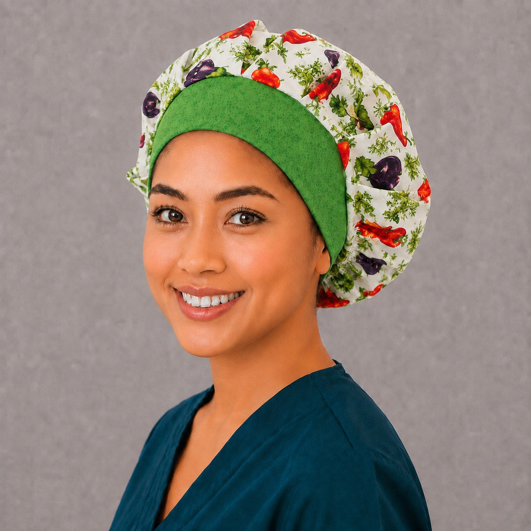 Woman wearing a garden vegetable bouffant scrub cap, right angled view — chili peppers and eggplants with a green batik band, adjustable women's surgical hat