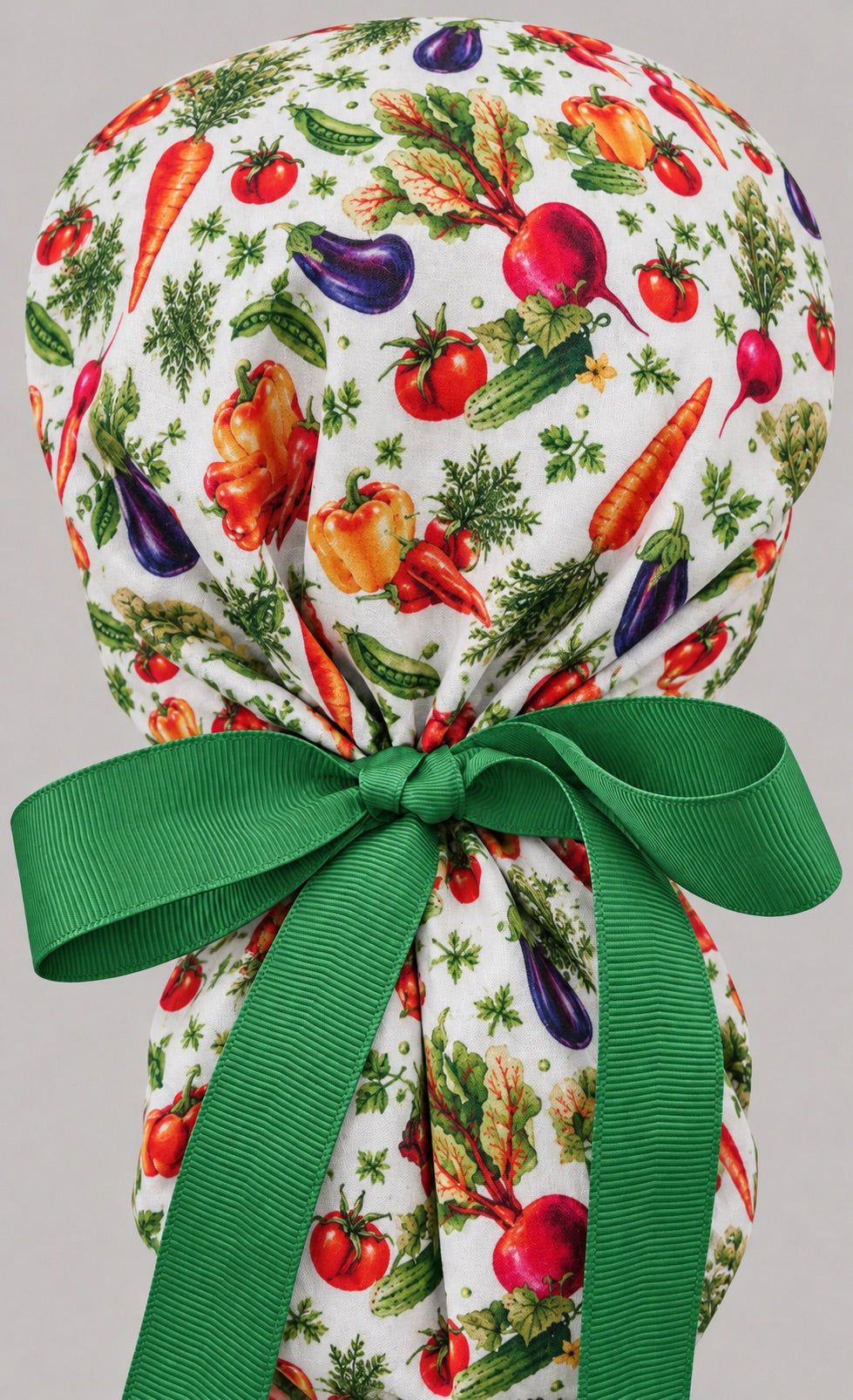 Back view of the garden veggie ponytail cap, showing the gathered crown and long green grosgrain ribbon tails tied in a wide bow