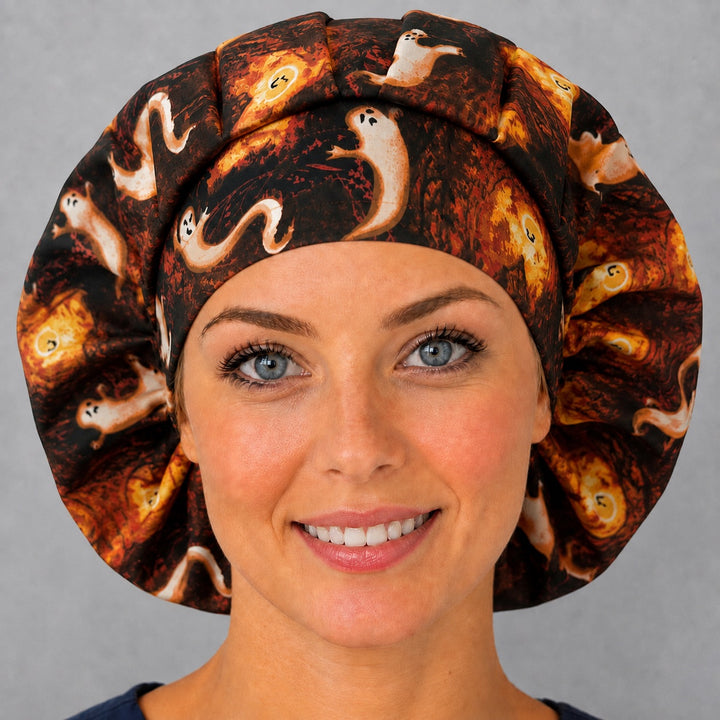 Back view of the ghost bouffant scrub cap — full gathered fit showing ghosts, haunted houses and glowing pumpkins across the crown