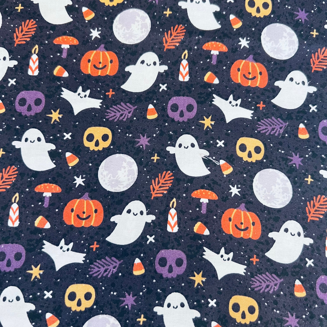 Close up of ghost, jack o lantern and candy corn fabric on midnight navy cotton, print detail of the Halloween tie back scrub cap