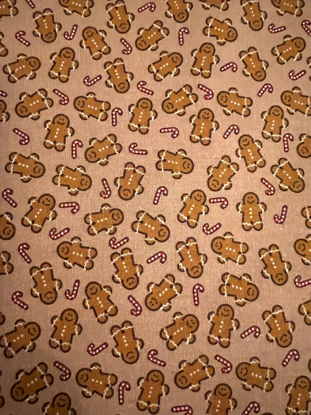 Close up of gingerbread man and candy cane fabric on toasted tan cotton, detail of the holiday tie back scrub cap
