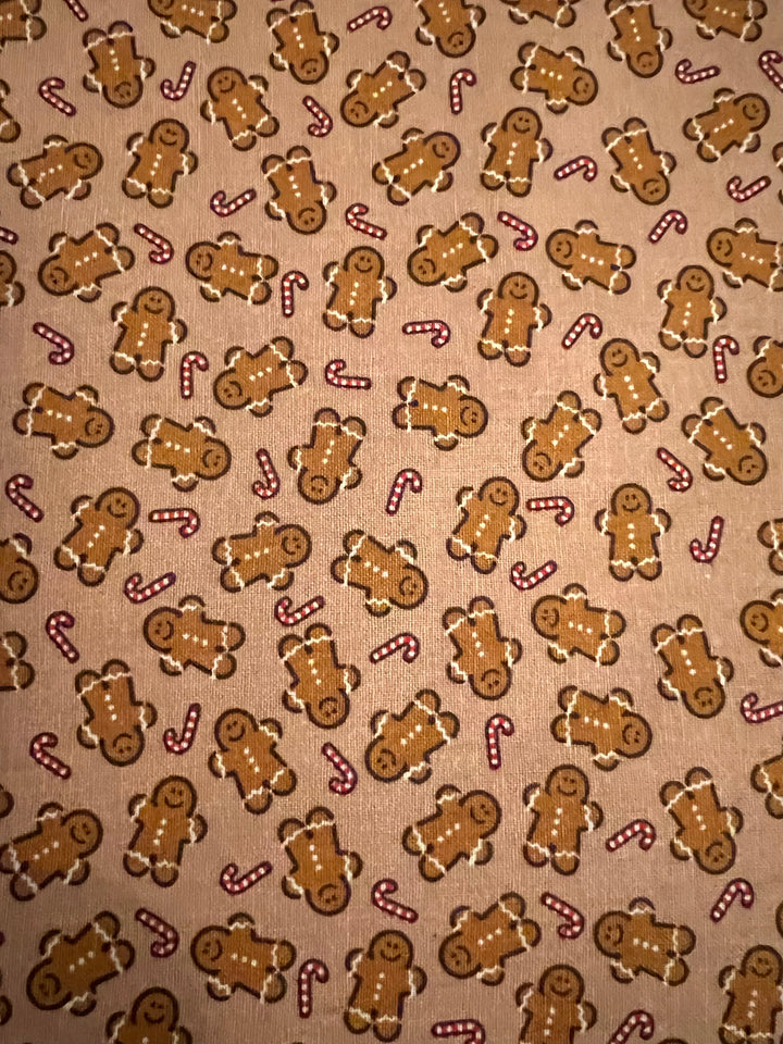 Close up of gingerbread man and candy cane fabric on toasted tan cotton, detail of the holiday tie back scrub cap