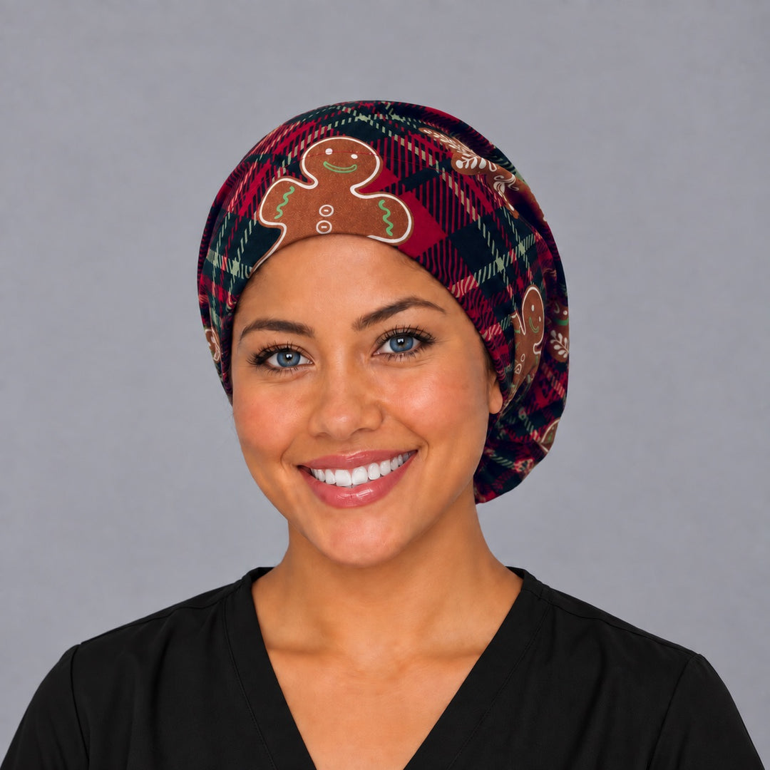 Woman wearing a gingerbread Euro scrub cap, front view — iced gingerbread men on red and navy plaid, adjustable Christmas surgical hat