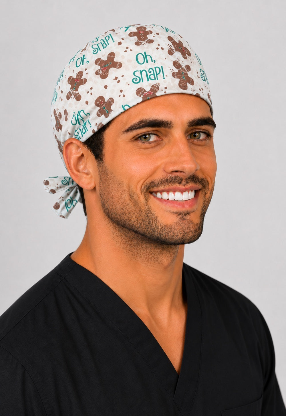Gingerbread Oh Snap Christmas scrub cap on cream, handmade men's tie-back funny holiday surgical hat on male OR nurse, front view