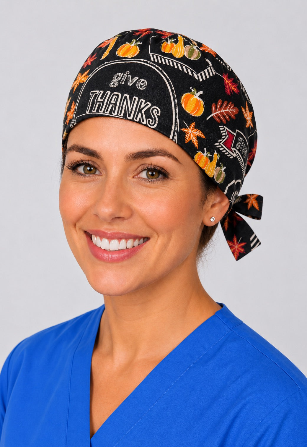 Nurse wearing Give Thanks Thanksgiving tie back scrub cap, black chalkboard fall surgical hat, front view by OR World