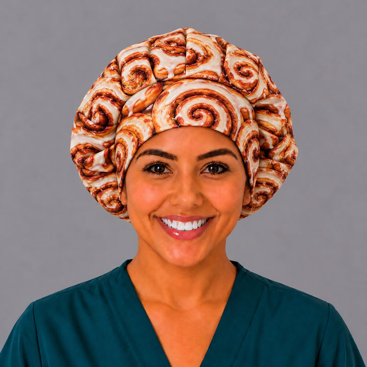 Front view of a glazed cinnamon roll bouffant scrub cap for women with long hair, a funny gift for nurses