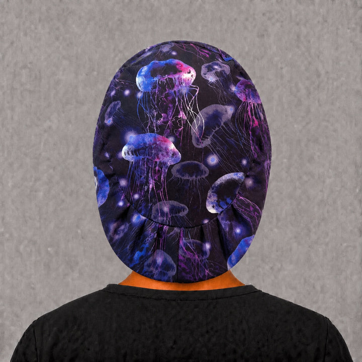 Back view of the glow jellyfish Euro scrub cap — full coverage showing glowing jellyfish and tentacles across the black crown