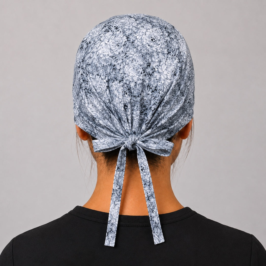 Back view of adjustable tie-back knot on light gray floral neutral unisex surgical hat