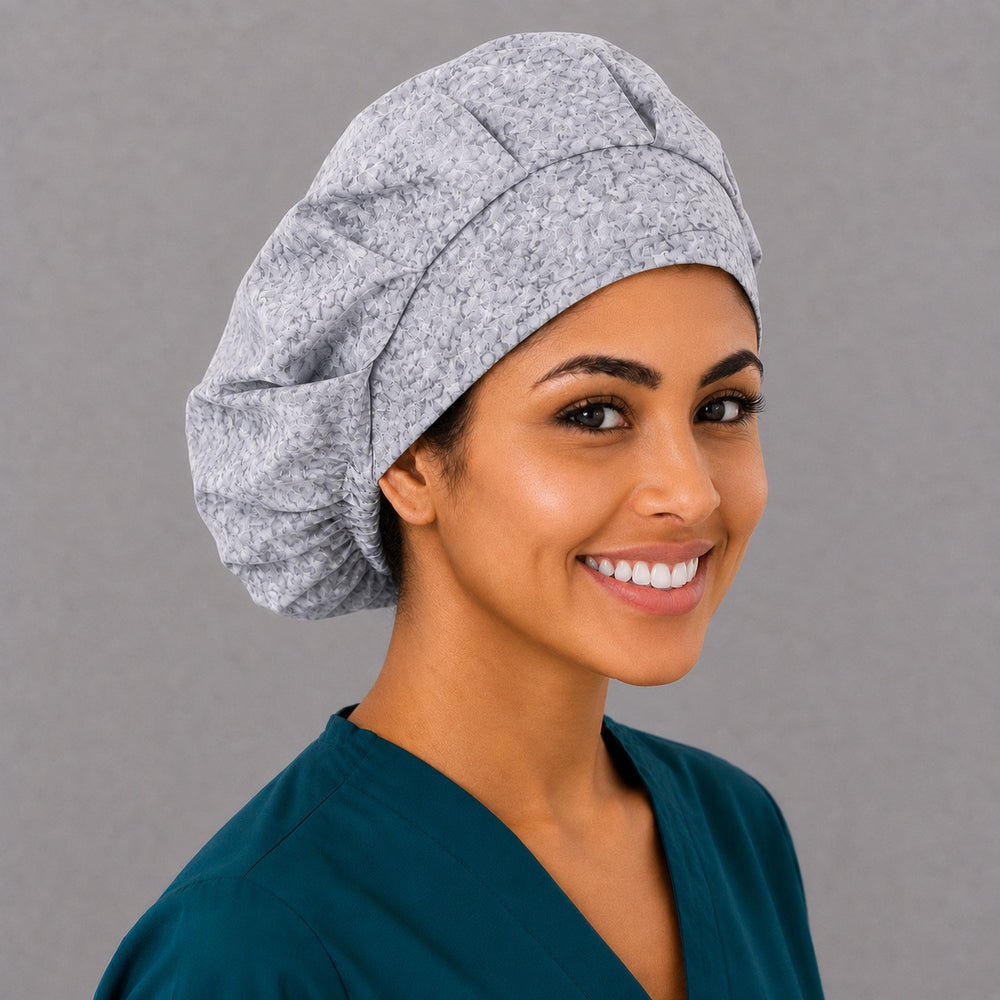 Gray rose bouffant scrub cap, right angled smiling view — subtle floral print for OR nurses and surgical techs