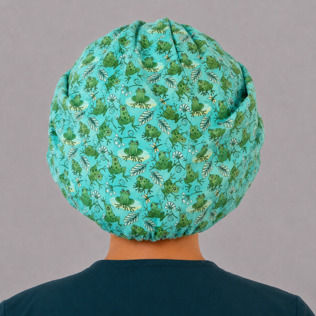 Back view of the green frog bouffant surgical hat — aqua-teal frog and dragonfly print with full roomy elastic gather, breathable cotton cap for nurses