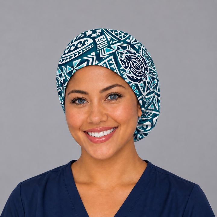 Woman wearing a Guardian of the Reef Euro scrub cap, front view — Hawaiian tribal spirals and honu turtles in teal and black, adjustable surgical hat