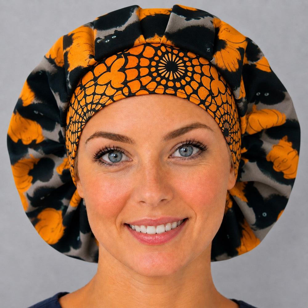 Woman wearing a Halloween black cat bouffant scrub cap, front view — black cats and orange pumpkins with spiderweb band, adjustable unisex surgical hat
