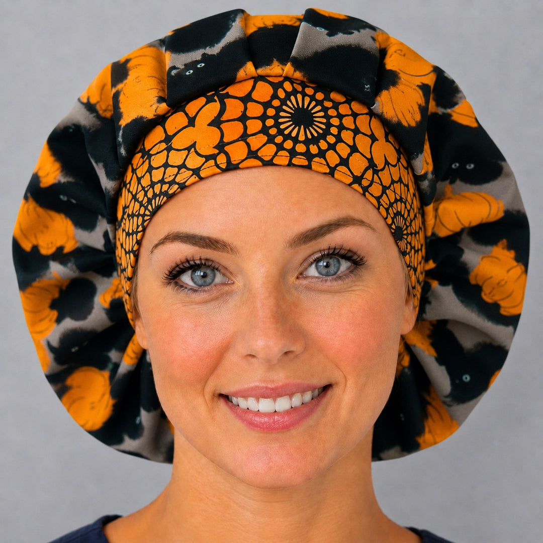 Woman wearing a Halloween black cat bouffant scrub cap, front view — black cats and orange pumpkins with spiderweb band, adjustable unisex surgical hat