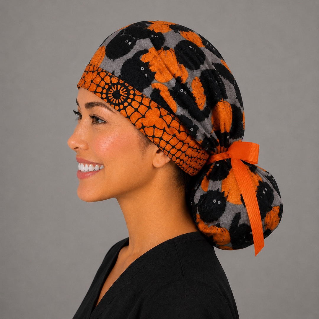 Halloween black cat and pumpkin ponytail scrub cap right side profile showing gathered pouch of black cats and orange pumpkins with orange pumpkin band and orange ribbon tie
