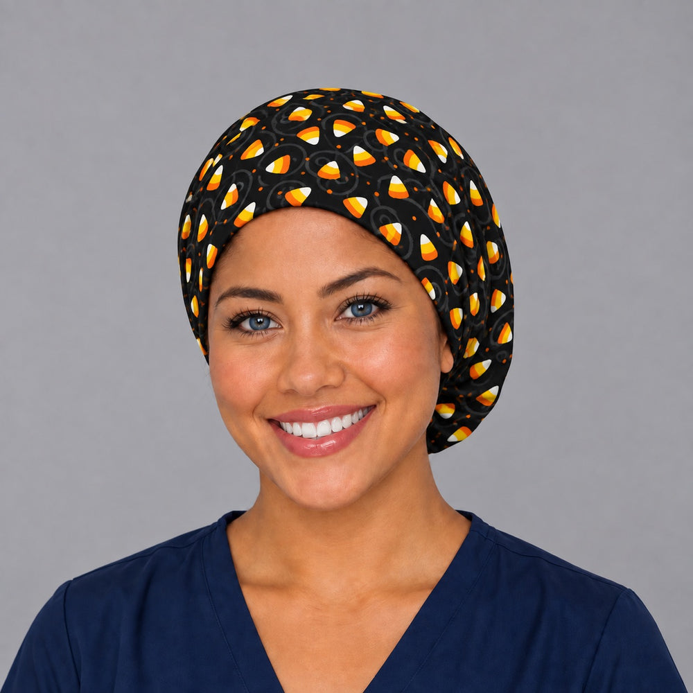 Woman wearing a Halloween candy corn Euro scrub cap, front view — orange and white candy corn on black, adjustable surgical hat