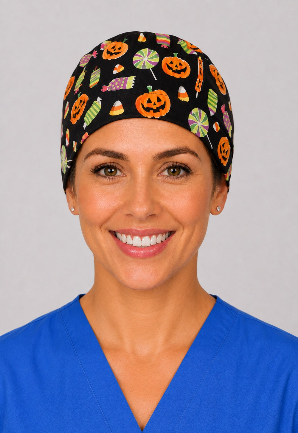Halloween candy corn and pumpkin scrub cap for short hair, handmade black tie-back surgical hat on OR nurse, front view