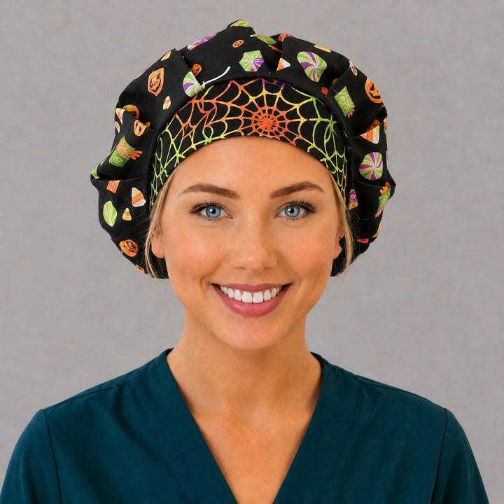 Halloween candy and pumpkin bouffant scrub cap for women, front view, candy corn, lollipops and jack-o-lanterns on black with rainbow spiderweb band, handmade nurse hat OR World