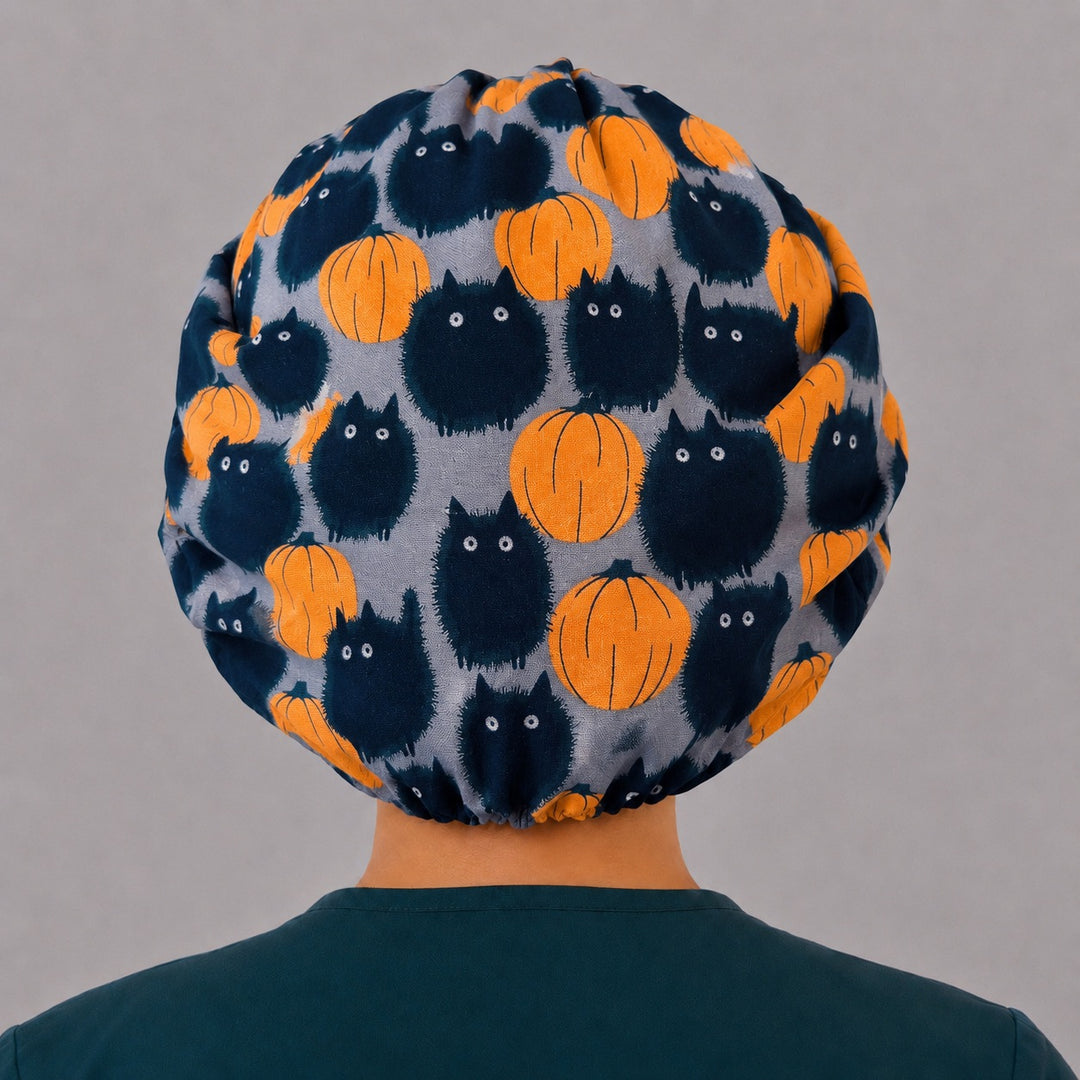 Back view of the Halloween cat and pumpkin bouffant scrub cap — full roomy fit showing fluffy black cats and orange pumpkins on grey