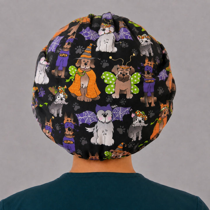 Back view of the Halloween dog bouffant scrub cap — full gathered coverage showing costumed dogs, spiderwebs and paw prints on black
