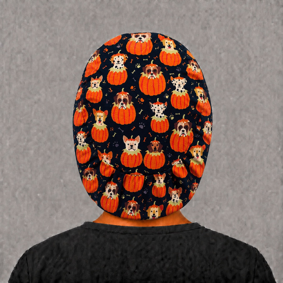 Back view of the Halloween dog Euro scrub cap — full coverage showing pumpkin puppies, bones and paw prints across the black crown