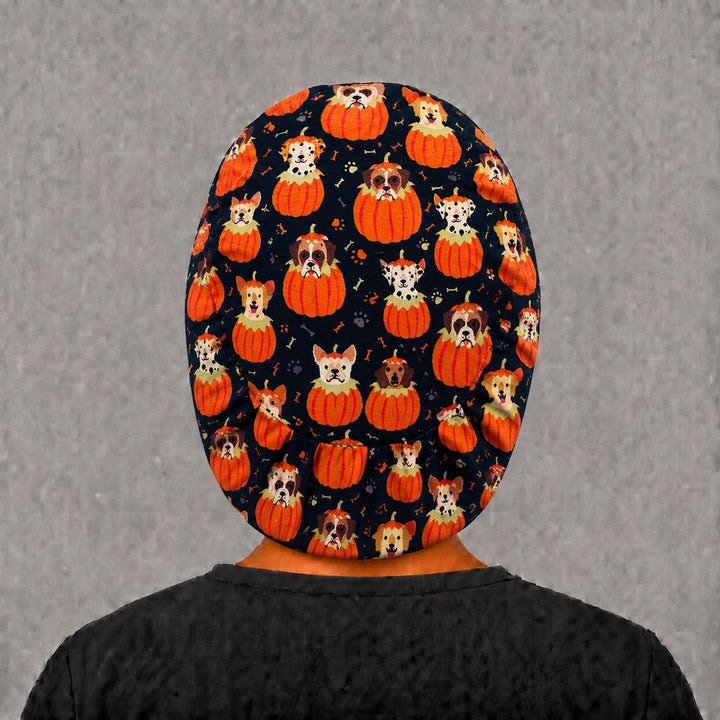 Back view of the Halloween dog Euro scrub cap — full coverage showing pumpkin puppies, bones and paw prints across the black crown
