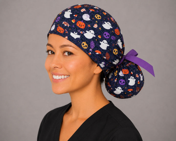 Cute ghost and pumpkin Halloween ponytail scrub cap right side profile with full ponytail pouch of ghosts, pumpkins and candy corn on navy and long purple ribbon ties