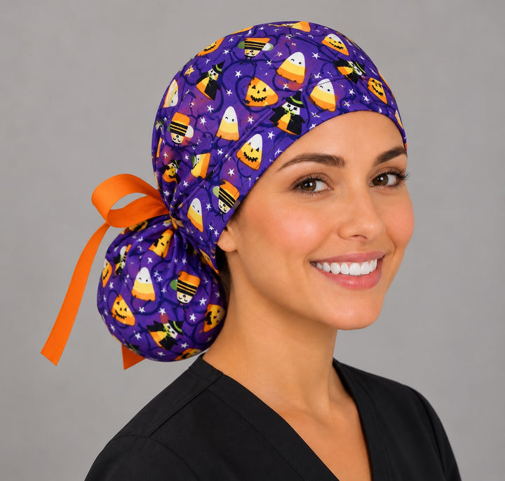 Halloween ponytail scrub cap, right side profile — orange bow and candy corn print for OR nurses and surgical techs
