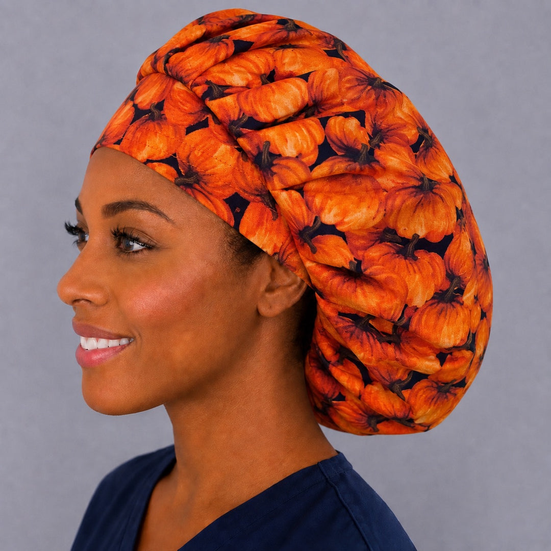 Halloween pumpkin bouffant cap for women, left side profile — handmade autumn surgical cap with roomy elastic back, USA made