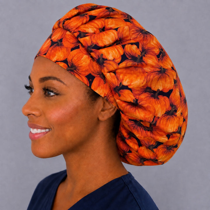 Halloween pumpkin bouffant cap for women, left side profile — handmade autumn surgical cap with roomy elastic back, USA made