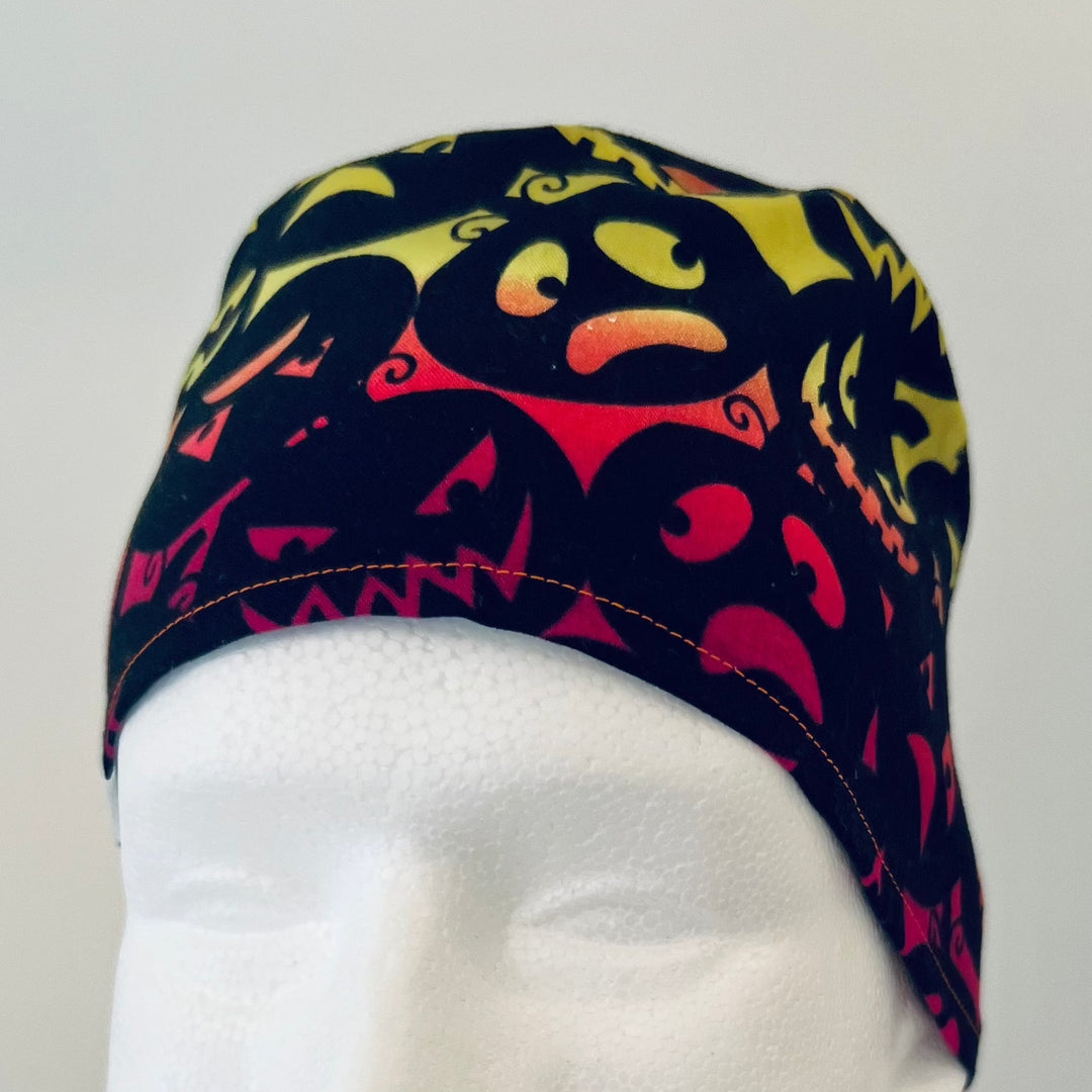 Front view of neon Halloween pumpkin-faces tie-back scrub cap — handmade USA surgical hat for OR nurses, surgeons &amp; techs.