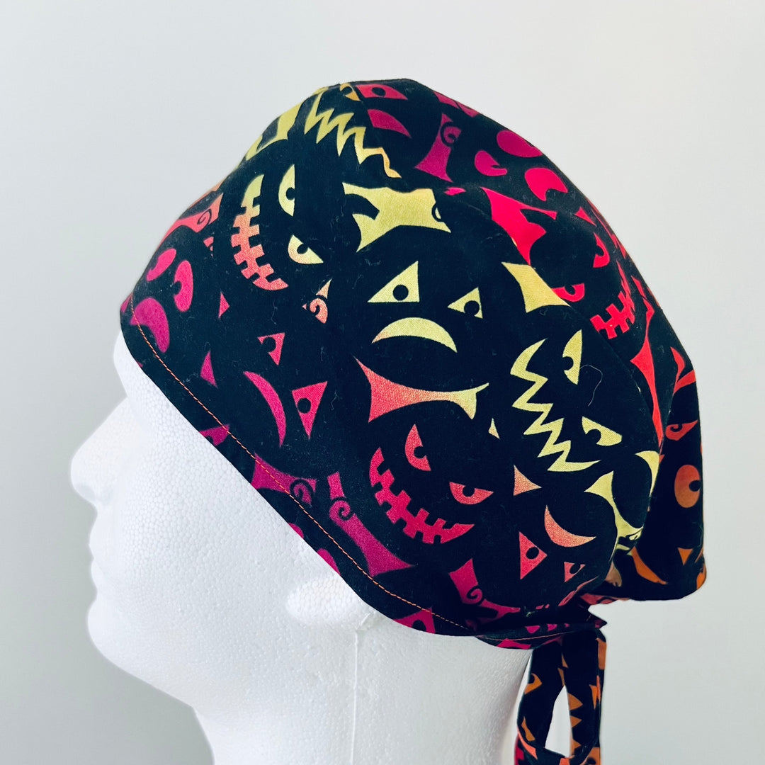 Side view of black &amp; neon Halloween pumpkin-faces tie-back scrub cap — handmade-in-USA OR World surgical hat for men &amp; women.