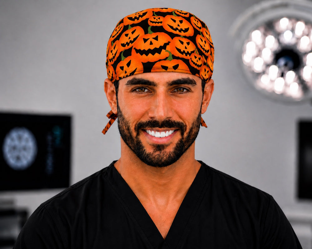 Halloween pumpkins scrub cap with carved orange jack-o'-lanterns on black, handmade men's tie-back surgical hat on male OR nurse, front view