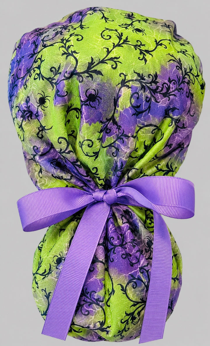 Halloween spider ponytail scrub cap back view close-up showing gathered pouch of black spiders and spider webs on purple and lime green with purple grosgrain ribbon bow