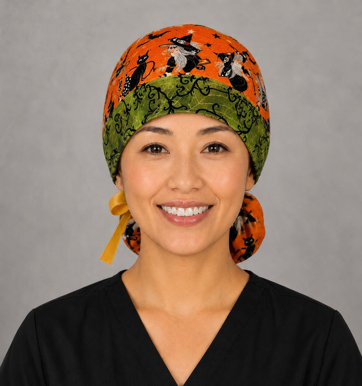 Halloween witch gnome ponytail scrub cap back view close-up showing gathered pouch full of witch gnomes, bats and stars on orange with yellow ribbon bow
