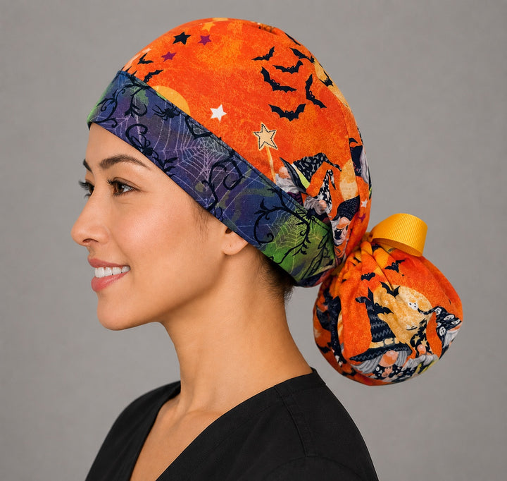 Halloween witch gnome ponytail surgical cap left side profile showing witch gnomes, bats and purple spiderweb band with yellow ribbon tie