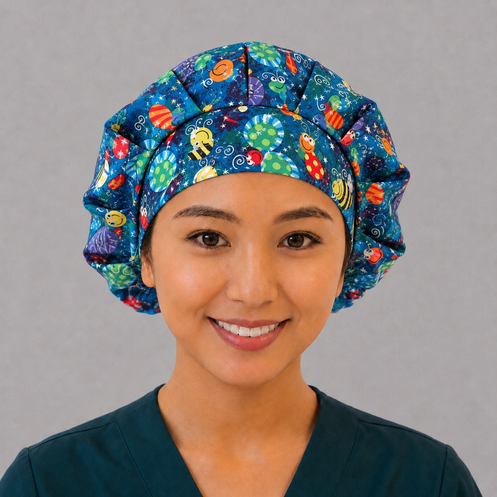 Woman wearing a happy bugs bouffant scrub cap, front view — smiling bees, butterflies and ladybugs on cobalt blue, adjustable women's surgical hat
