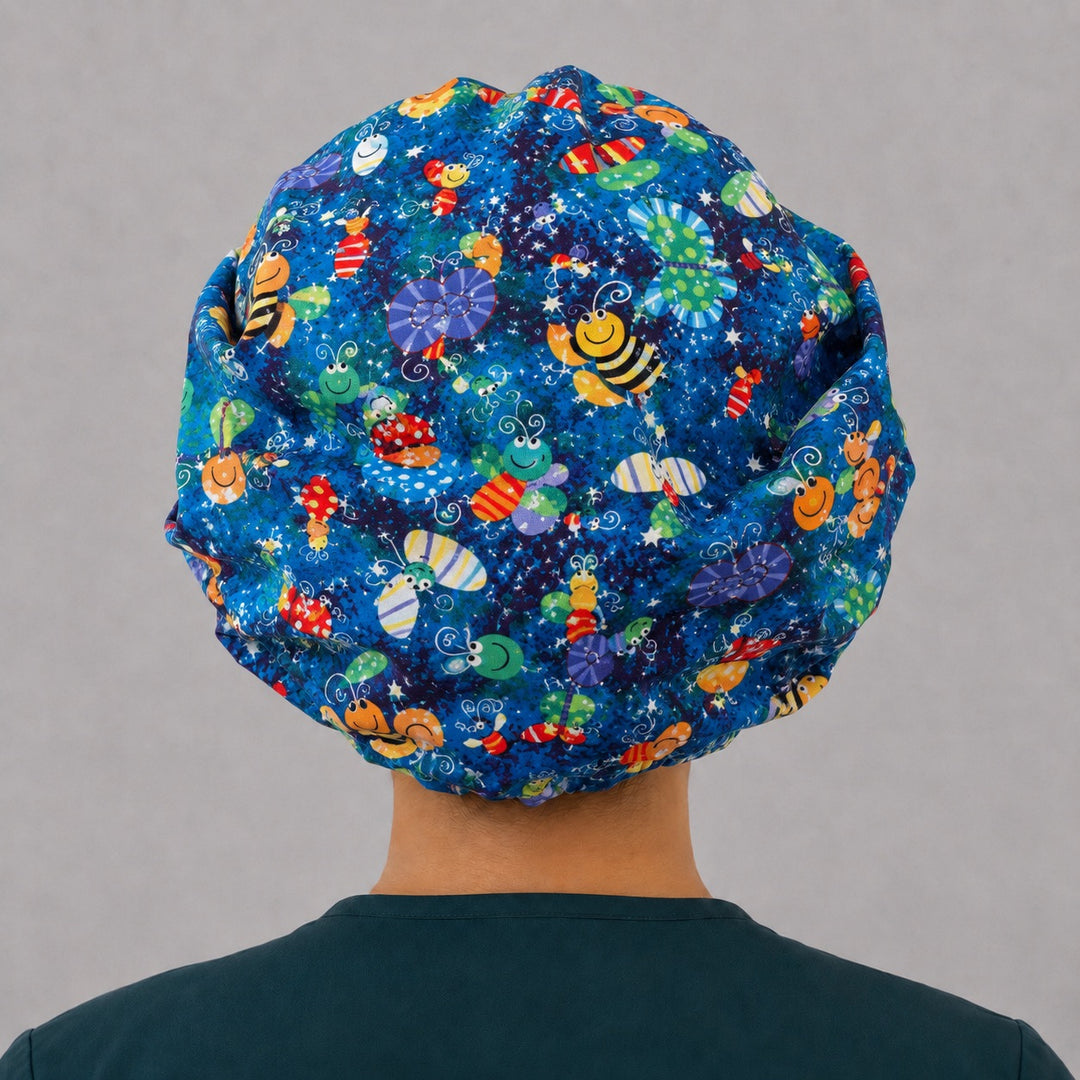 Back view of the happy bugs bouffant scrub cap — full roomy fit showing butterflies, bees and caterpillars on a starry blue print