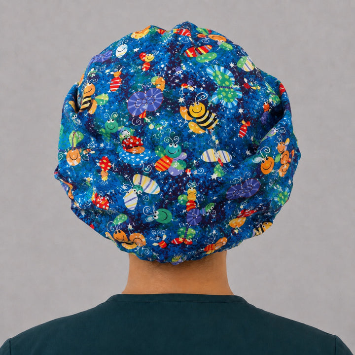 Back view of the happy bugs bouffant scrub cap — full roomy fit showing butterflies, bees and caterpillars on a starry blue print