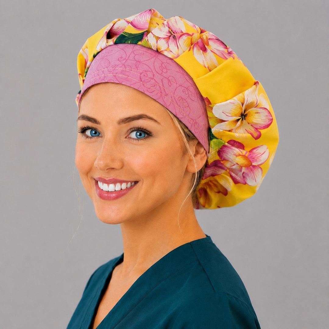 Hawaiian tropical floral bouffant scrub cap left side profile showing yellow and pink plumeria with pink swirl band, women's tropical surgical hat OR World