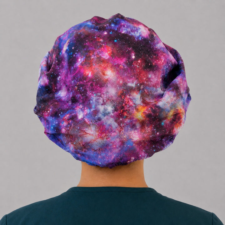 Healing Horizons galaxy bouffant scrub cap back view showing full purple magenta and blue nebula star print, OR World celestial surgical hat